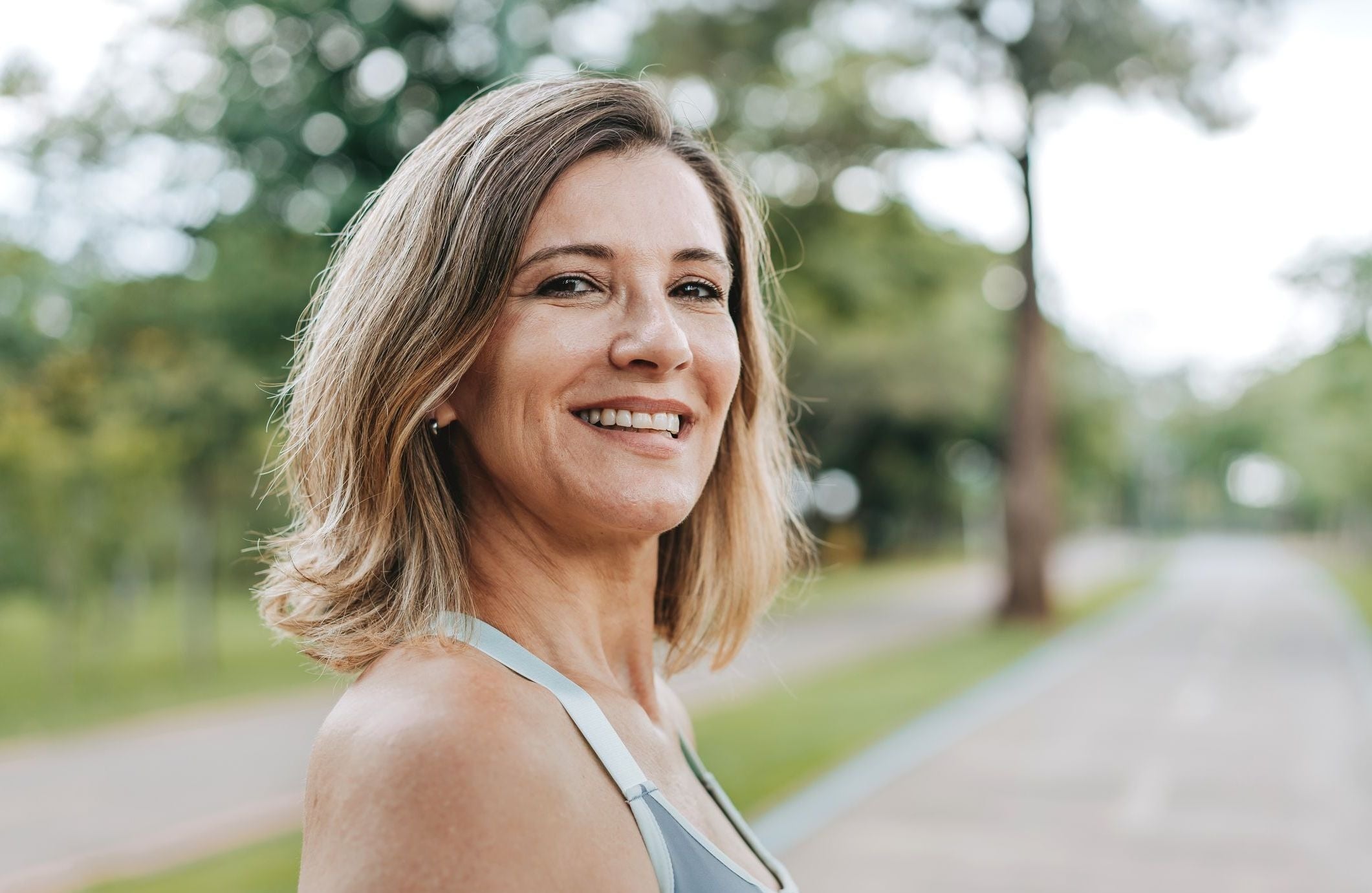 A smiling woman considering the impact of sequence of returns risk on her retirement planning.